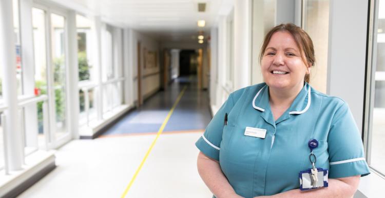 A nurse standing in a hallway in a hospital